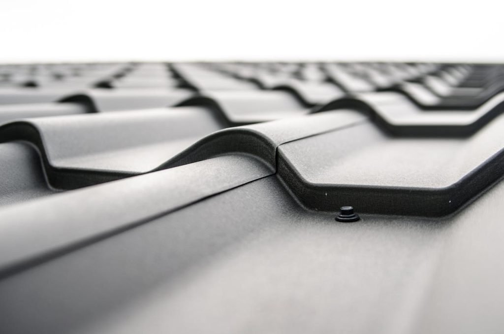 Close-up view of a metal roofs wavy design showcasing rivets and structural detail.